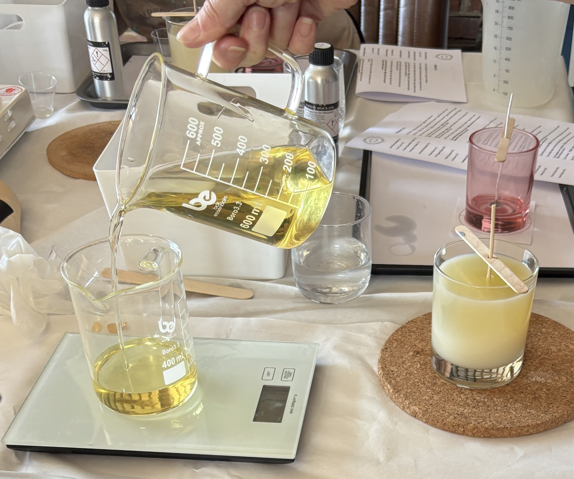 Two people making candles together at a workshop table