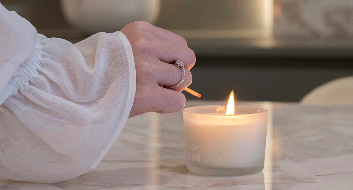 A single candle flame glowing against a dark background