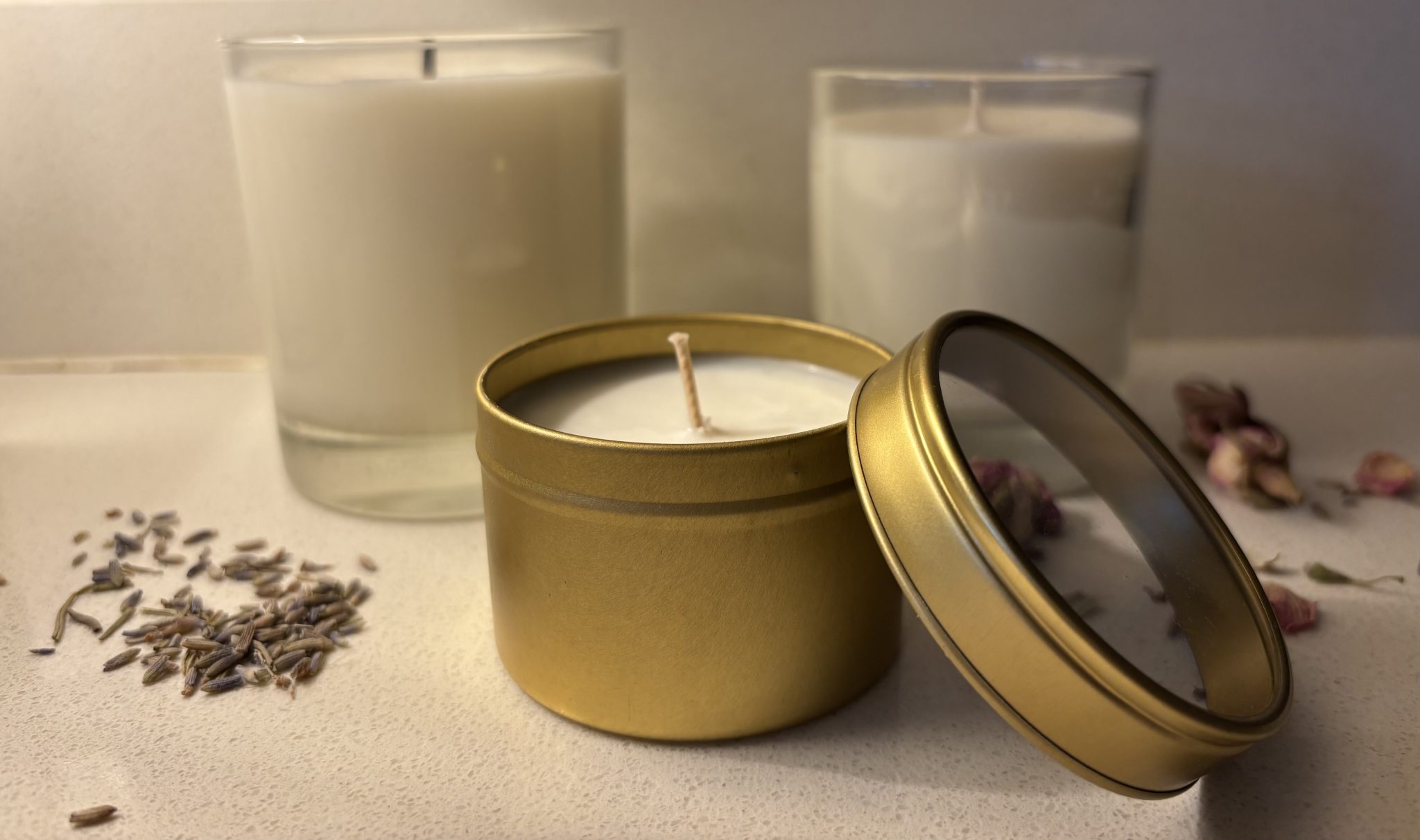 A lit candle in a glass holder glowing in a darkened room